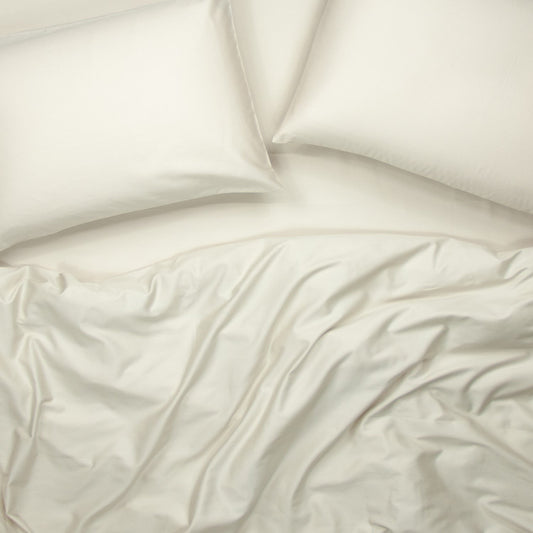 Birds eye view of organic cotton quilt cover set with pillowcases and quilt cover in egg shell white