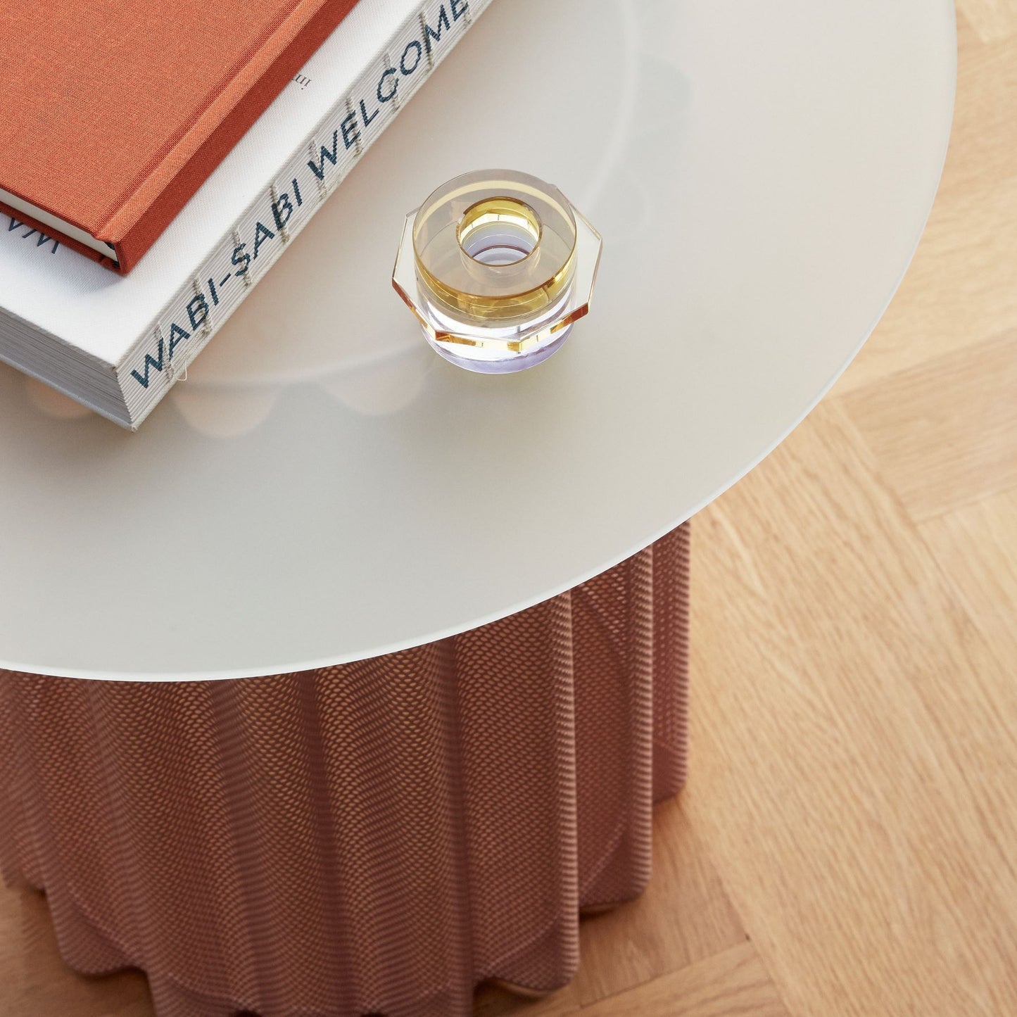 Hubsch Interior clement candle holder set in lilac and gold sitting on books on a side table