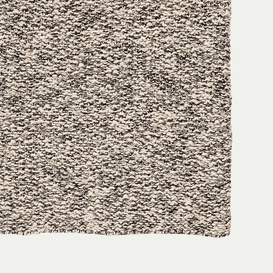 Close up of a Hubsch Interior boucle cotton knitted throw blanket in grey, white and cream on white background