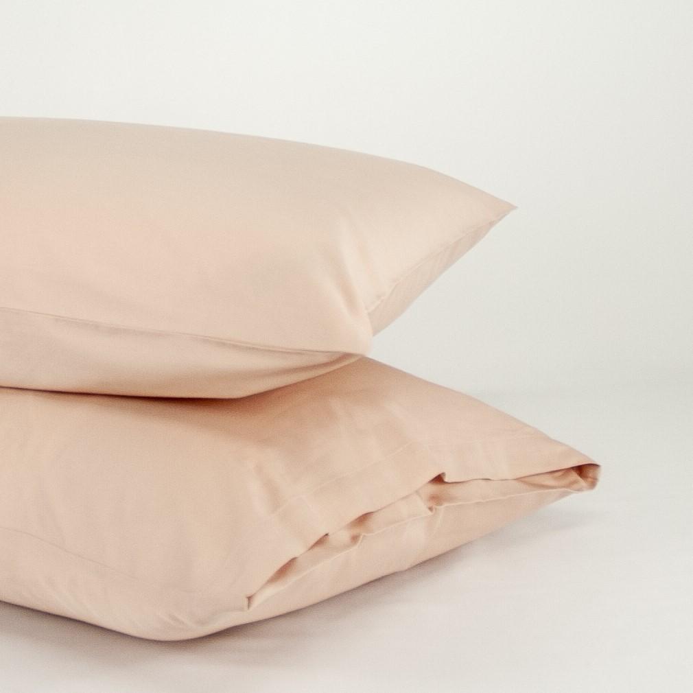 Stacked organic cotton pillowcases in blush pink