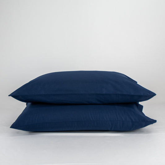 Stacked organic cotton pillowcases in classic blue