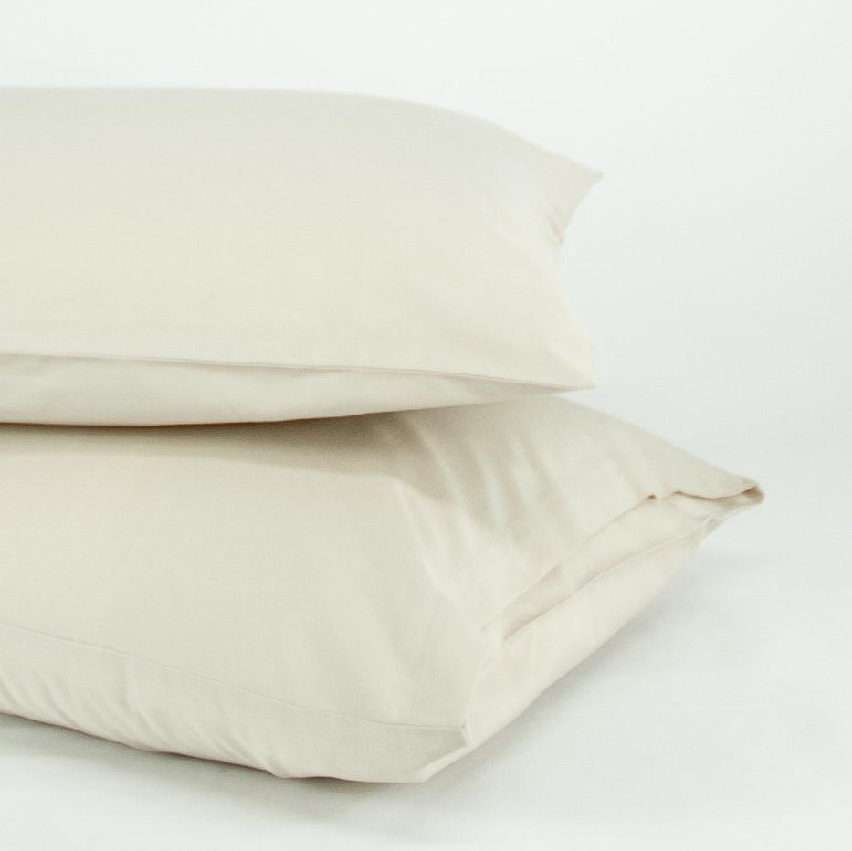 Stacked organic cotton pillowcases in egg shell white
