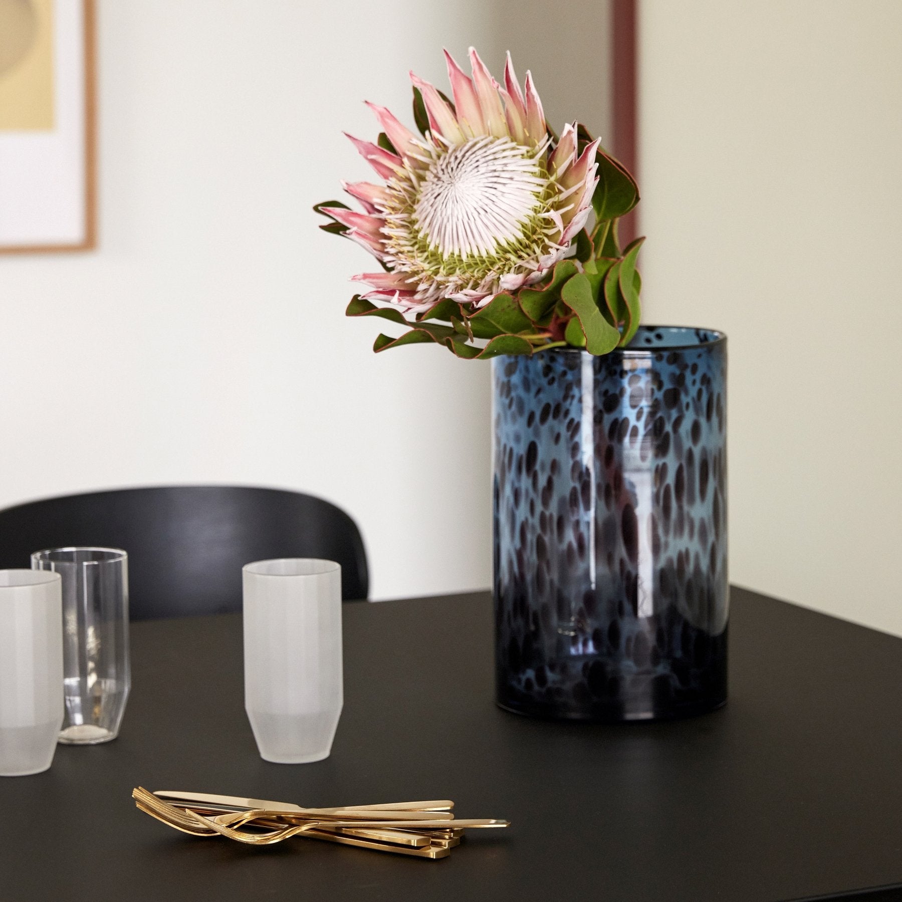 Hubsch Interior Nordic designer medium cylinder vase in blue glass with burgundy dot texture on table with flower