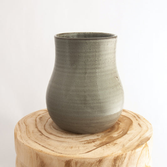 Robert Gordon pottery botanica banksia grey vase sitting on a natural wooden round side table