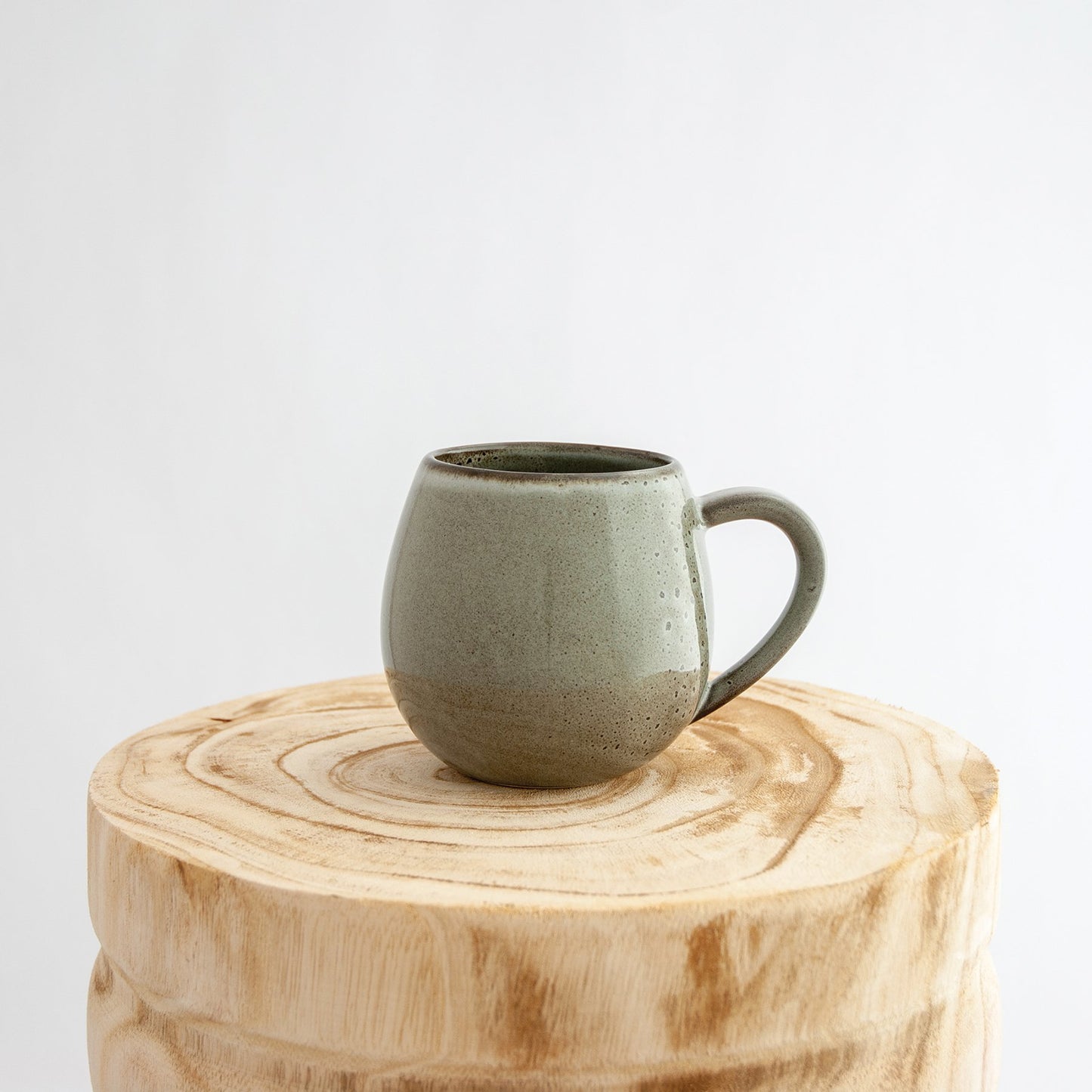 Robert Gordon banksia grey canvas mug coffee cup sitting on a natural wooden round side table