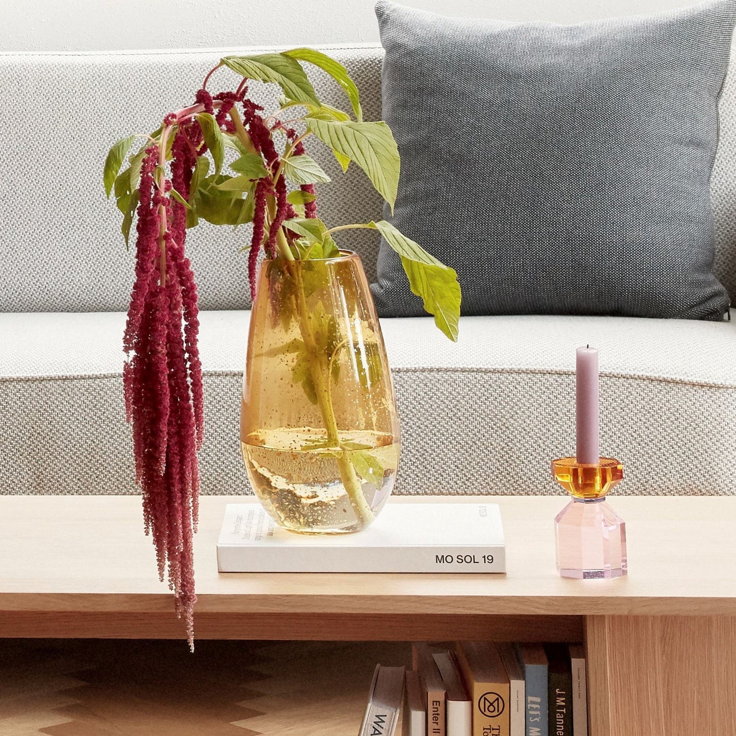 Hubsch Interior Scandi style champagne vase in amber glass with brass fleck on coffee table with candle holder and books