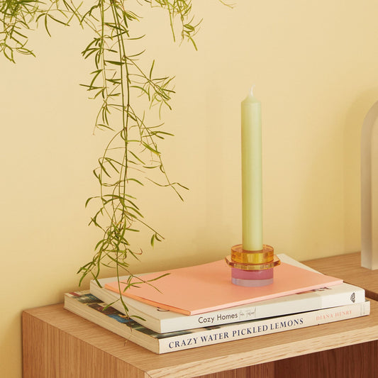 Hubsch Interior clement candle holder set in lilac and gold sitting on books on a side cabinet