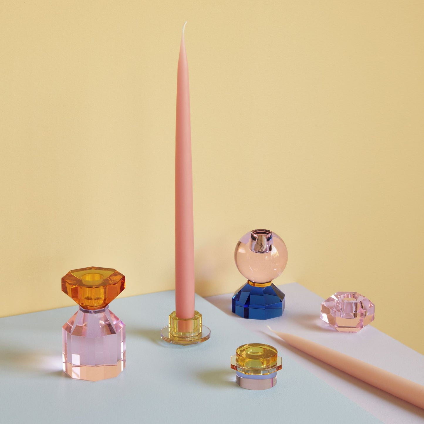 Hubsch Interior clement candle holder set in lilac and gold sitting on table with other glass candleholders