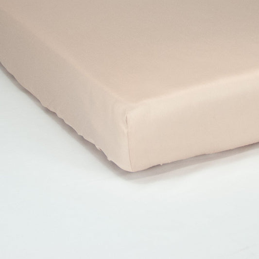 Corner of mattress with organic cotton fitted cot sheet in blush pink