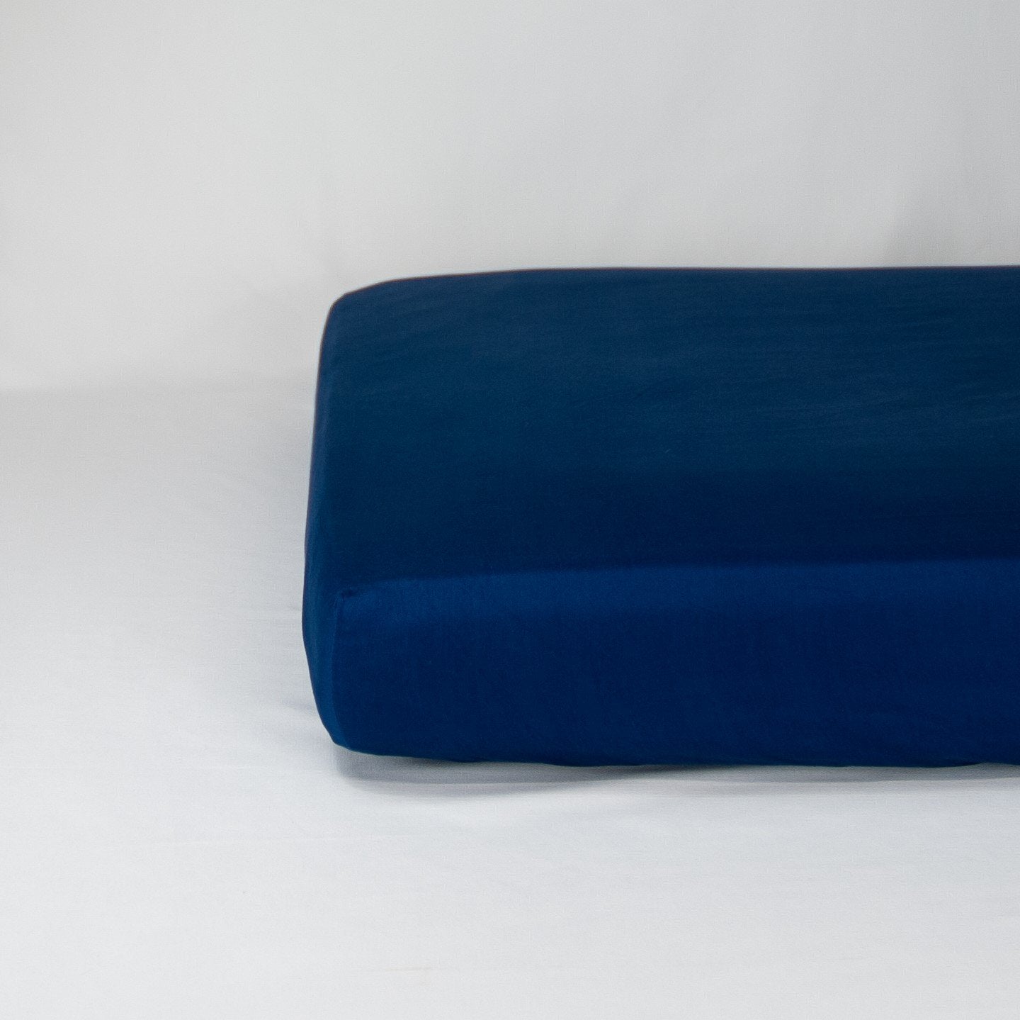 End of mattress with organic cotton fitted cot sheet in classic blue