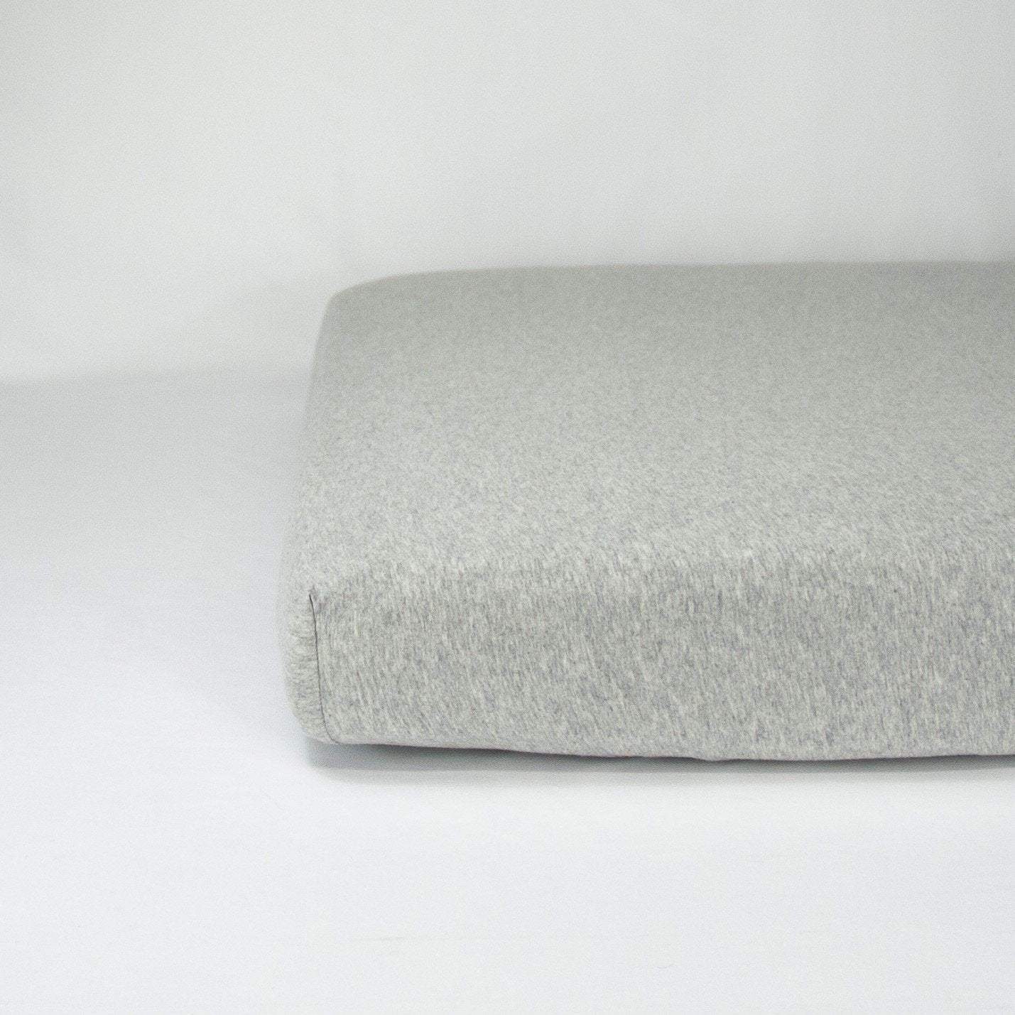 End of mattress with organic jersey fitted cot sheet in cloud grey