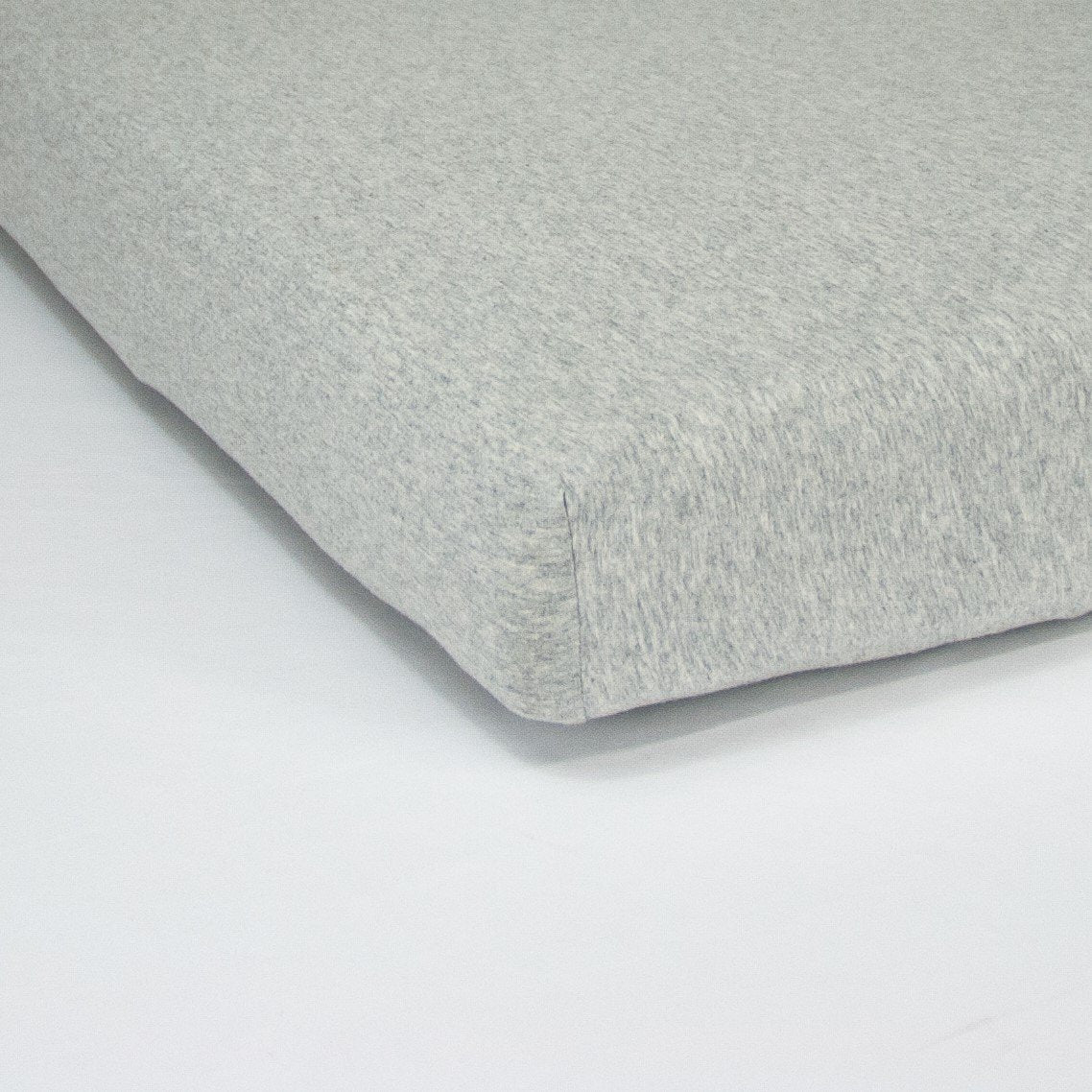 Corner of mattress with organic jersey fitted cot sheet in cloud grey