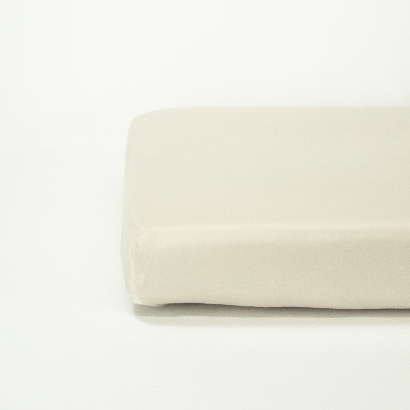 End of mattress with organic cotton fitted cot sheet in egg shell white