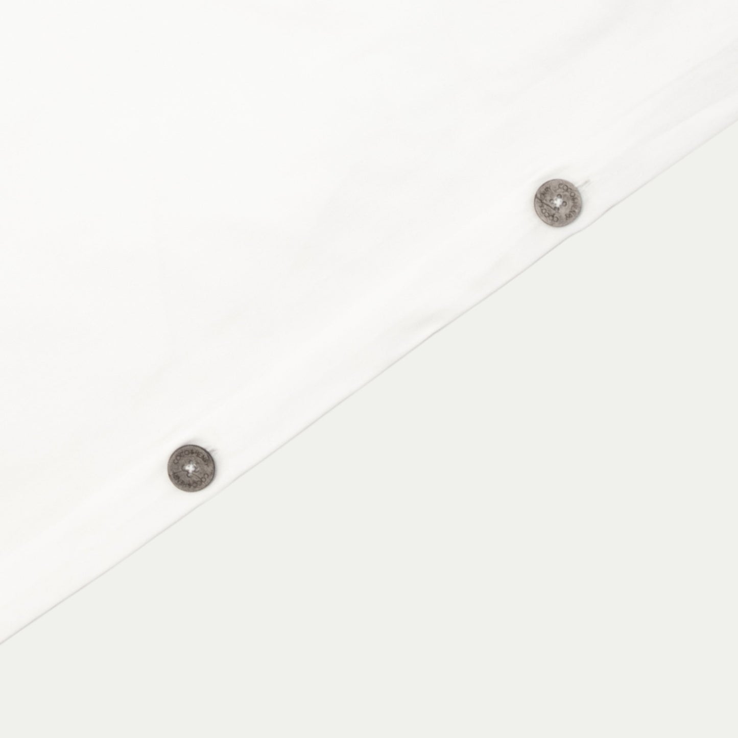 Close up of quilt cover edge with coconut buttons in pure white