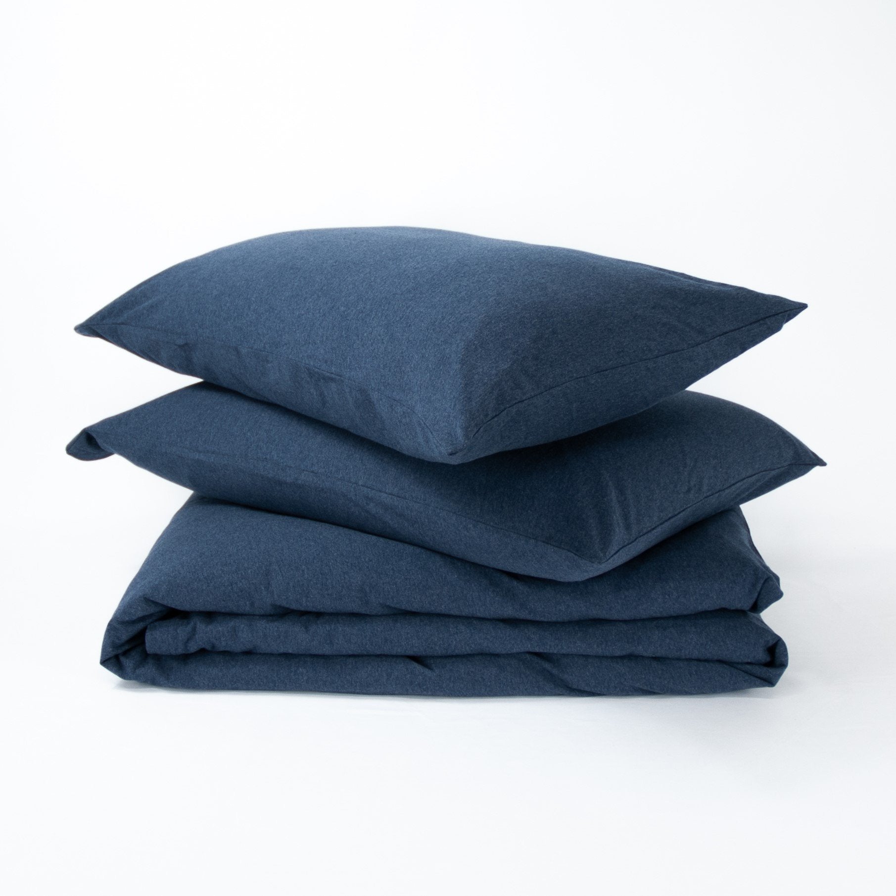 Stack of organic jersey quilt cover set with pillowcases and folded quilt cover in indigo blue
