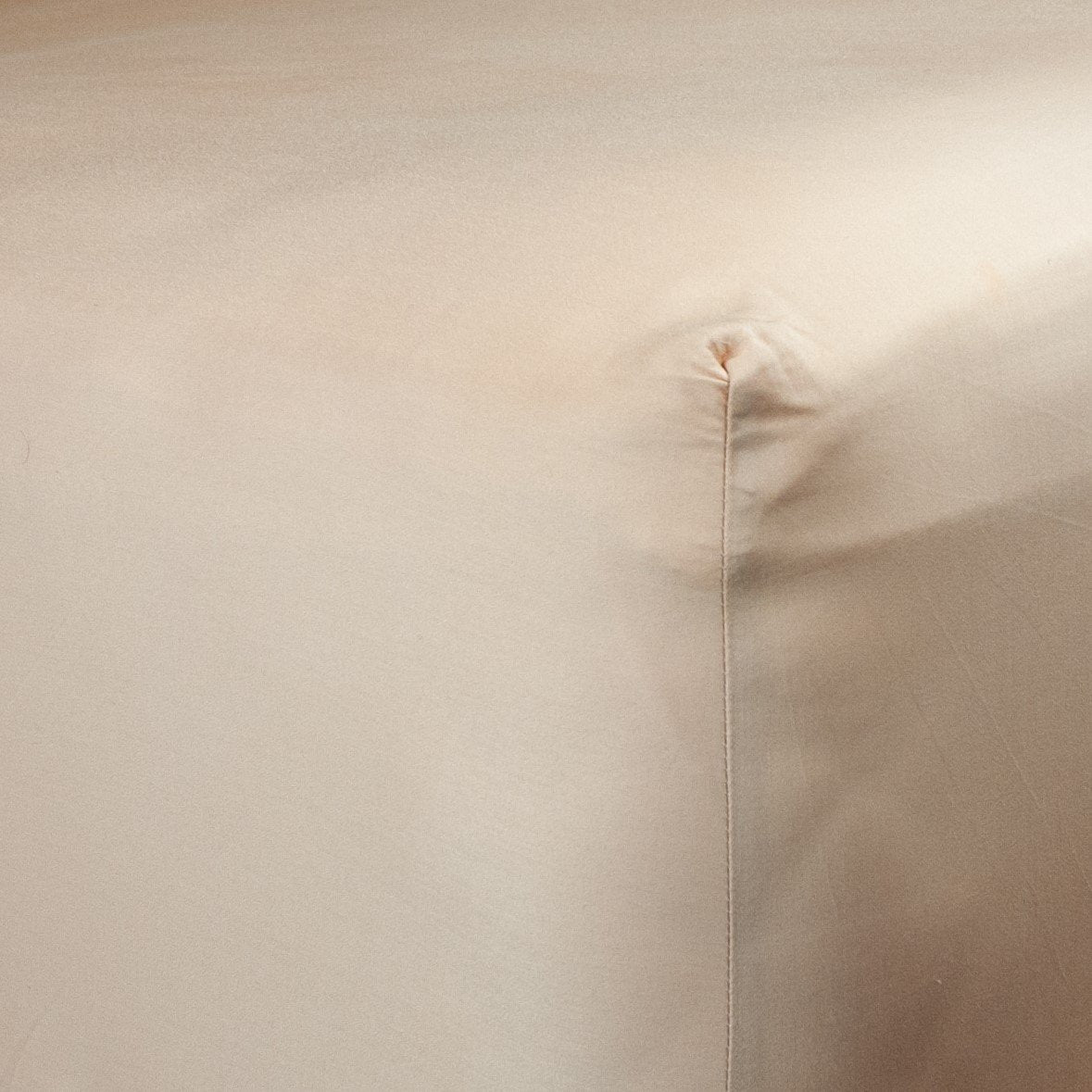 Corner of bed with organic cotton fitted sheet in blush pink