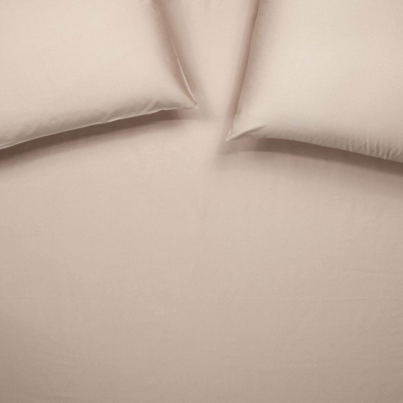 Birds eye view of organic cotton fitted sheet with pillowcases in blush pink
