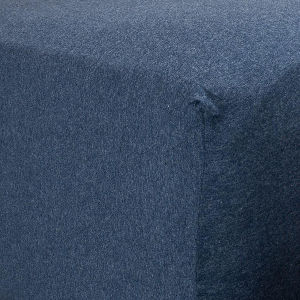 Corner of bed with organic jersey fitted sheet in indigo blue
