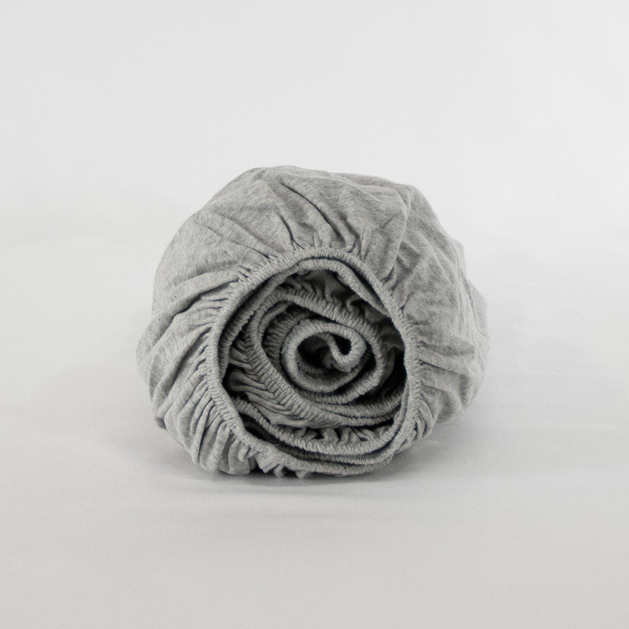 Rolled up organic cotton fitted cot sheet in cloud grey