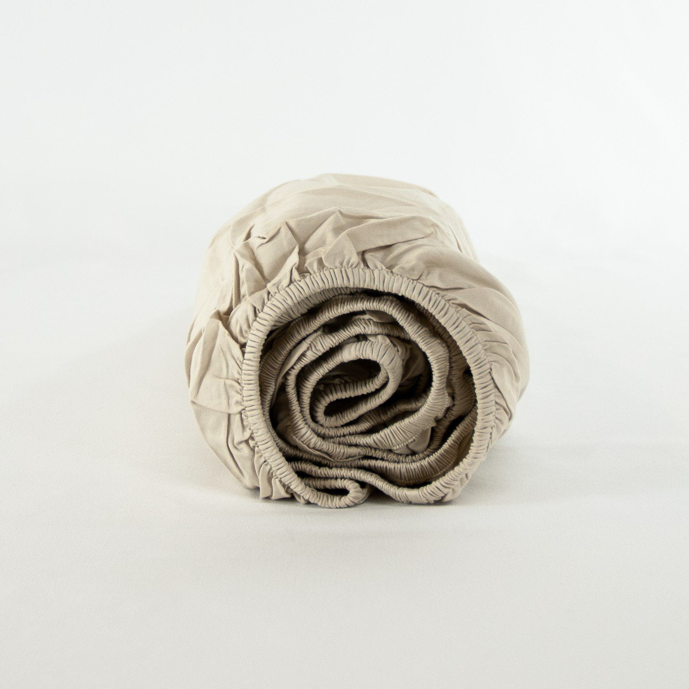 Rolled up organic cotton fitted sheet in egg shell white