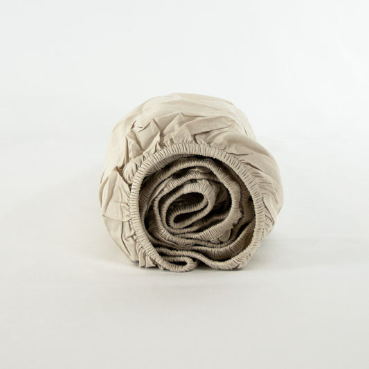Rolled up organic cotton fitted sheet in egg shell white