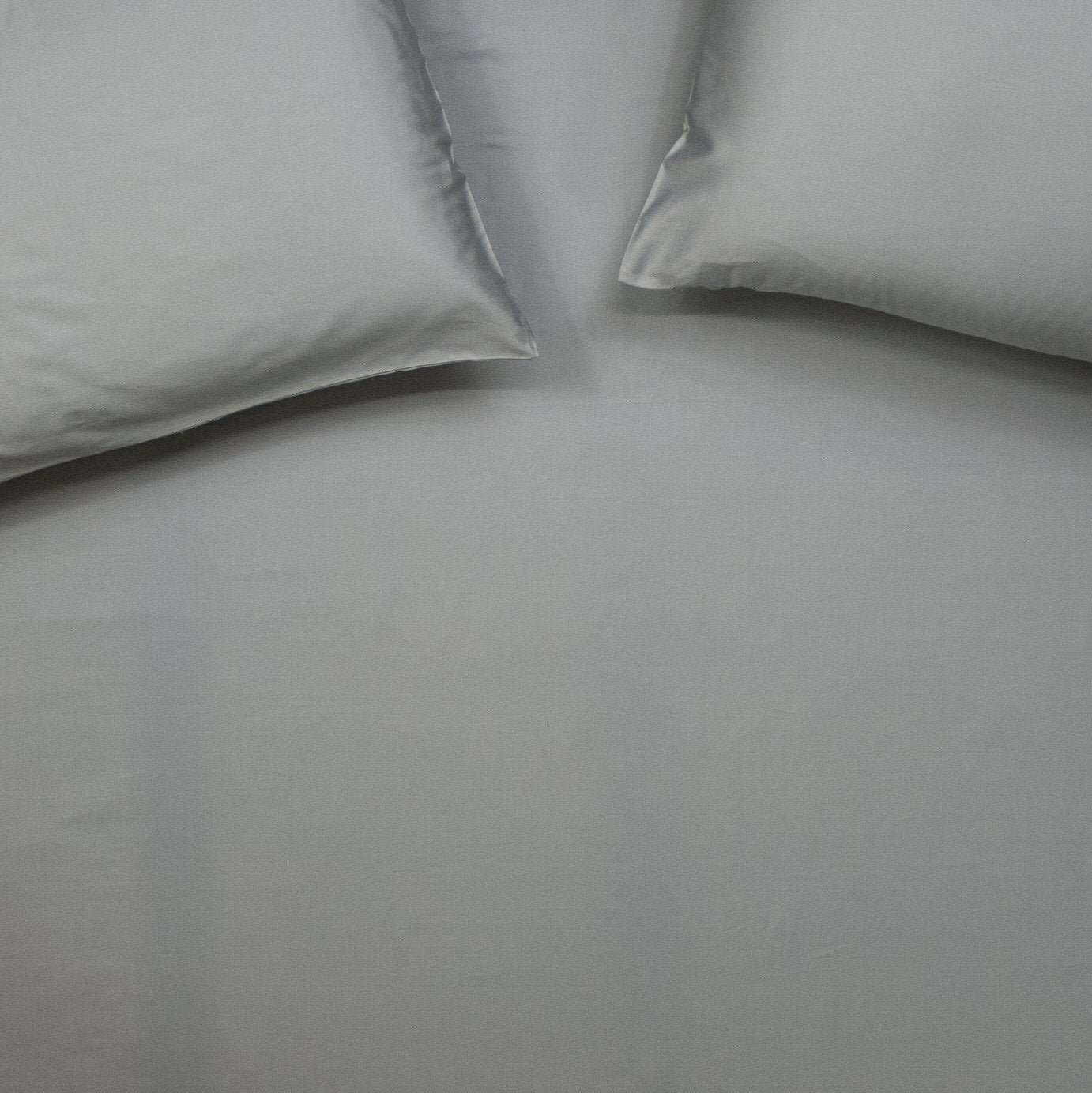 Birds eye view of organic cotton fitted sheet with pillowcases in sleet grey