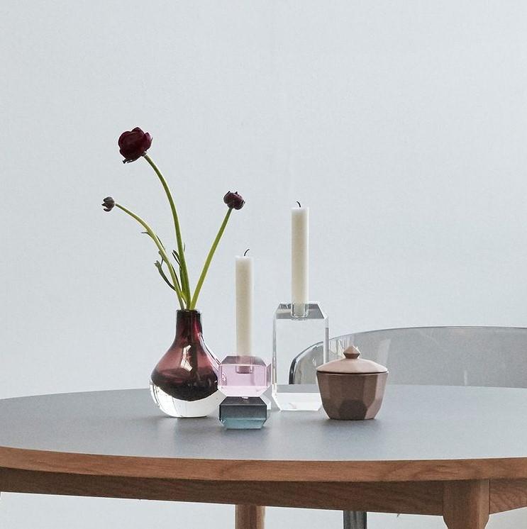 Hubsch Interior modern gem-like candle holders in clear, grey and pink glass on black dining table with candles and vases