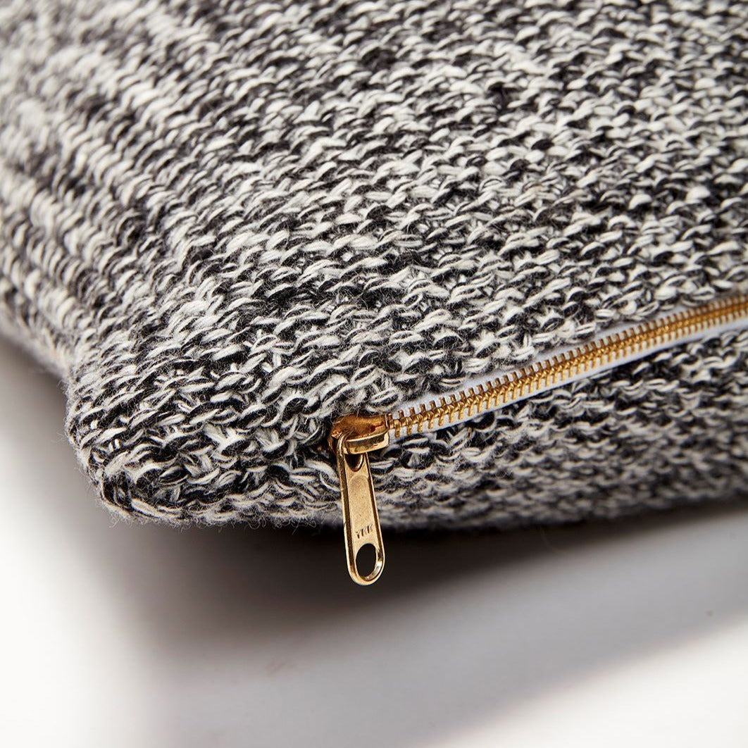 Close up of the gold zip detail on a Hubsch Interior large 60 x 60 boucle cushion in grey, white and cream on white background