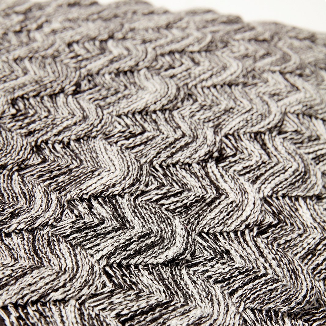 Close up of a Hubsch Interior large oversized cotton scale knit cushion in charcoal grey and cream on white background