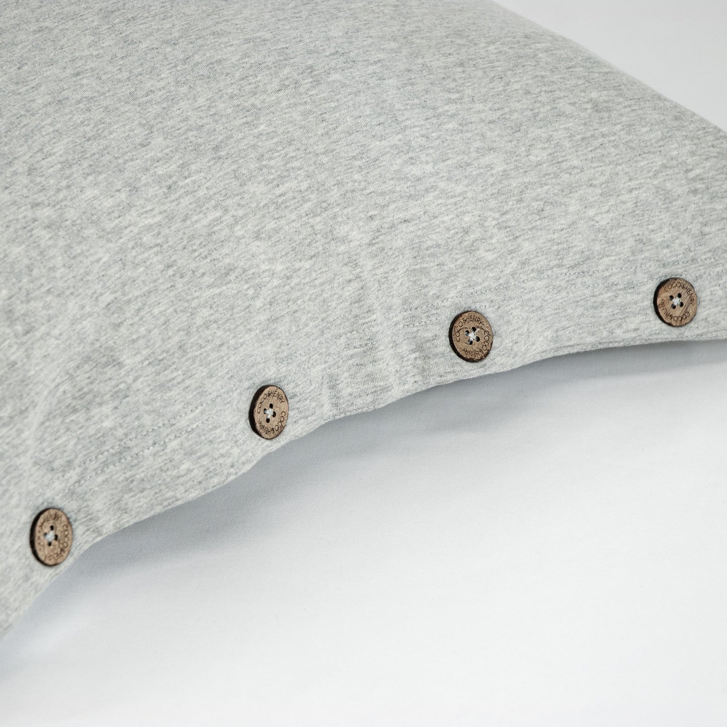 Close up of pillowcase edge with coconut buttons in cloud grey