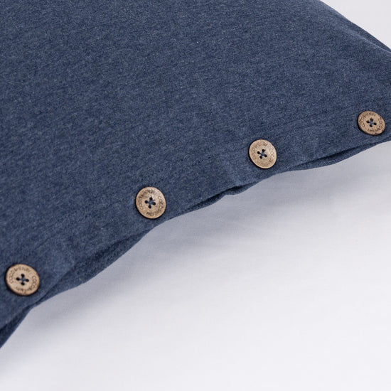 Close up of pillowcase edge with coconut buttons in indigo blue