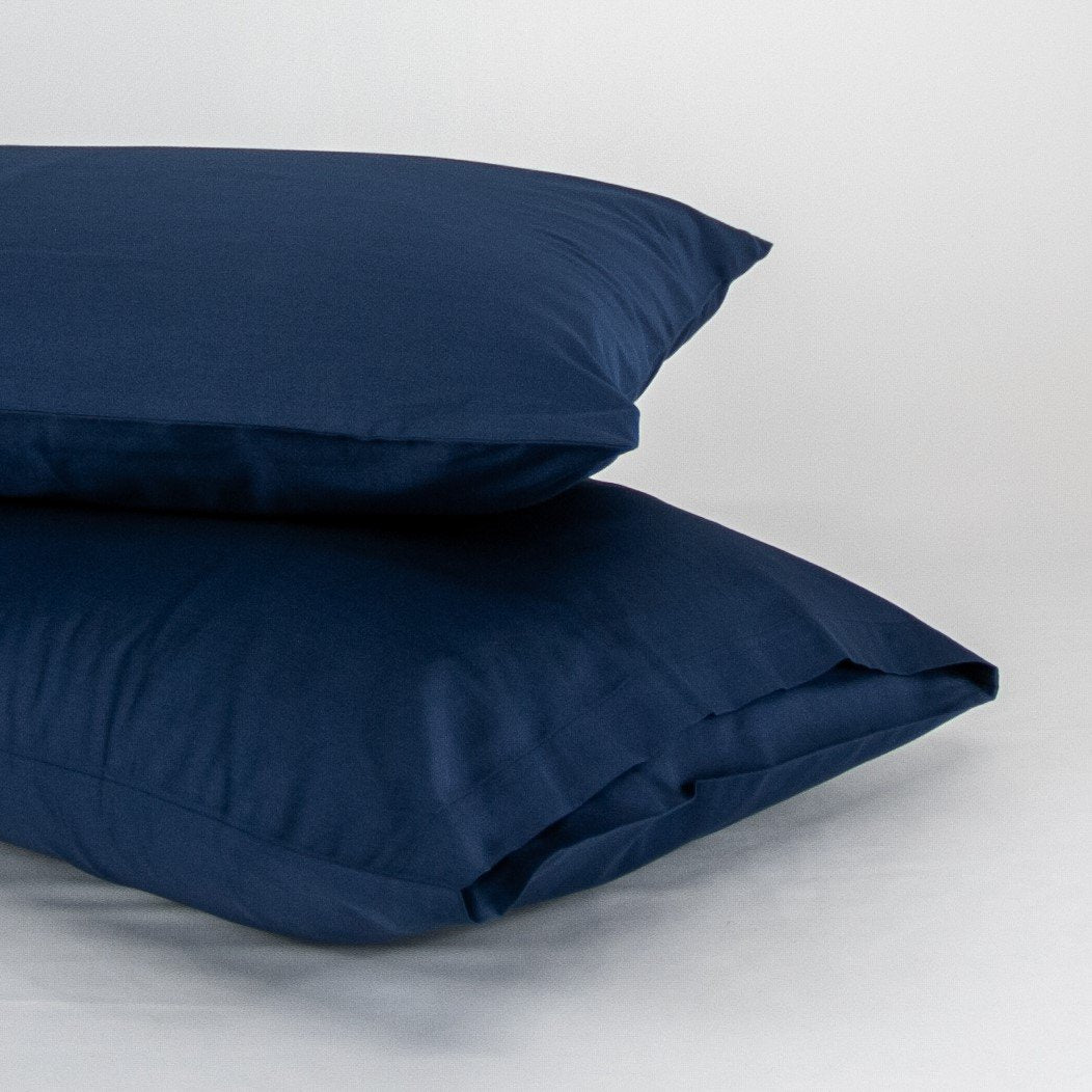 Stacked organic cotton pillowcases in classic blue