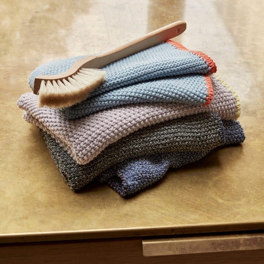 Stack of Hubsch Interior Scandi designer tea towels in various colours of cotton knit, folded in a pile on a kitchen bench