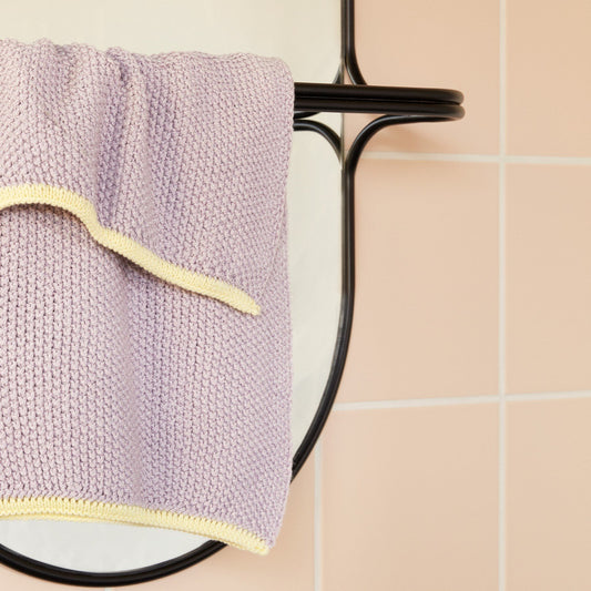 Hubsch Interior Scandi designer tea towel in lilac purple and yellow cotton knit hanging on a black towel rail