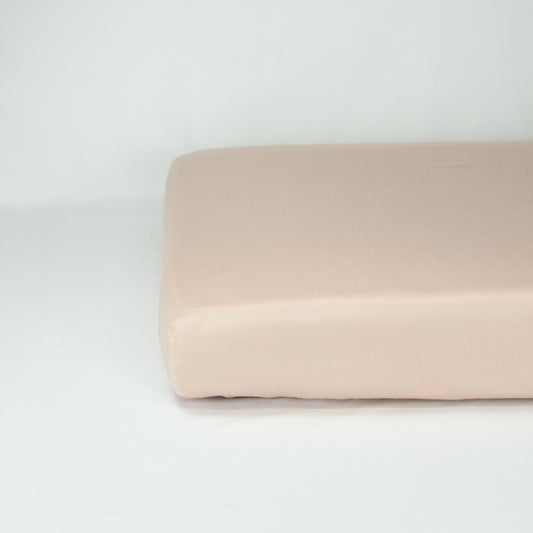 End of mattress with organic cotton fitted cot sheet in blush pink