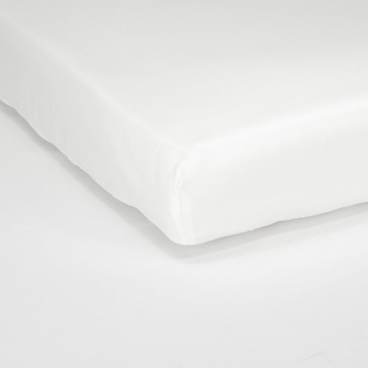Corner of mattress with organic cotton fitted cot sheet in pure white