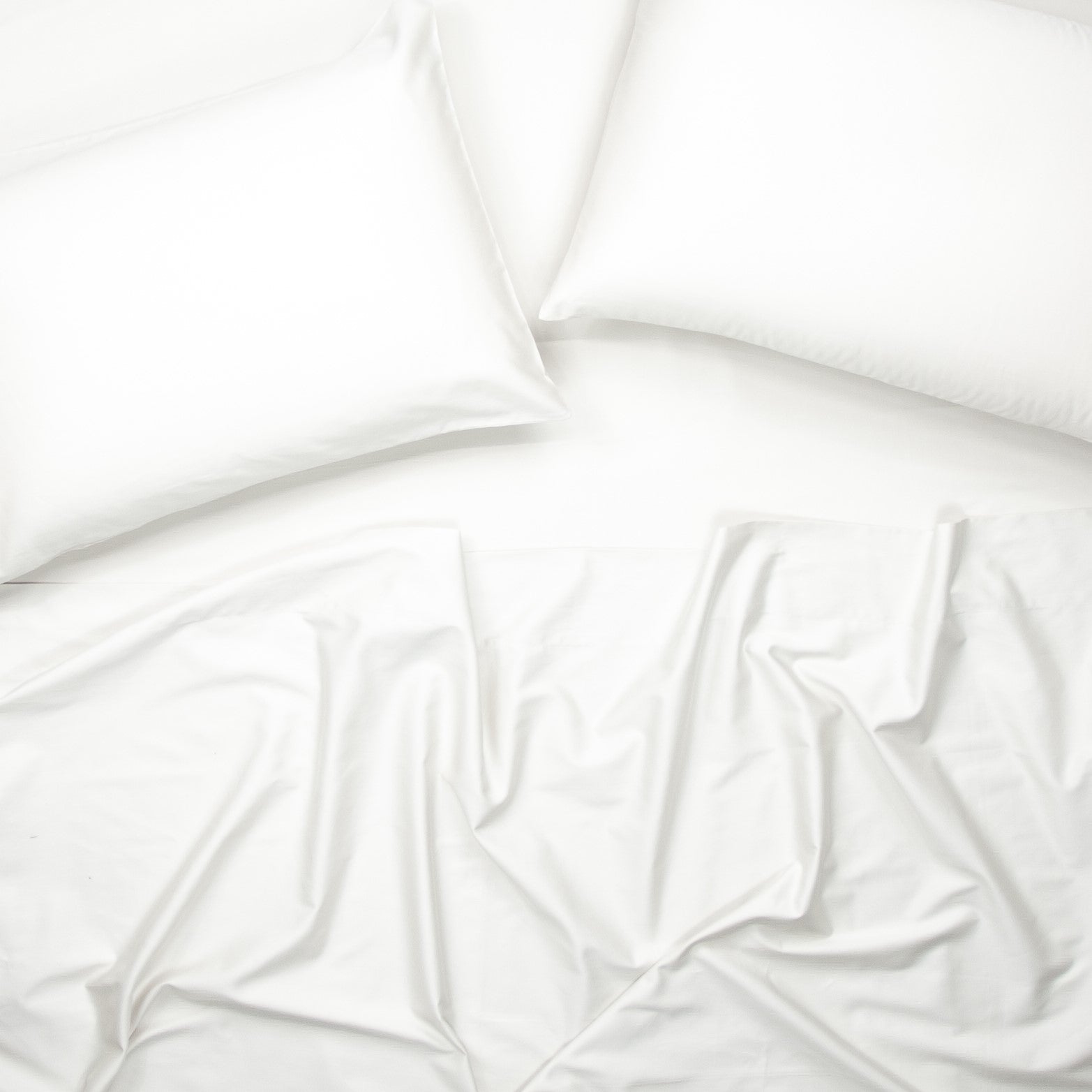 Birds eye view of organic cotton bed sheets with pillowcases in pure white